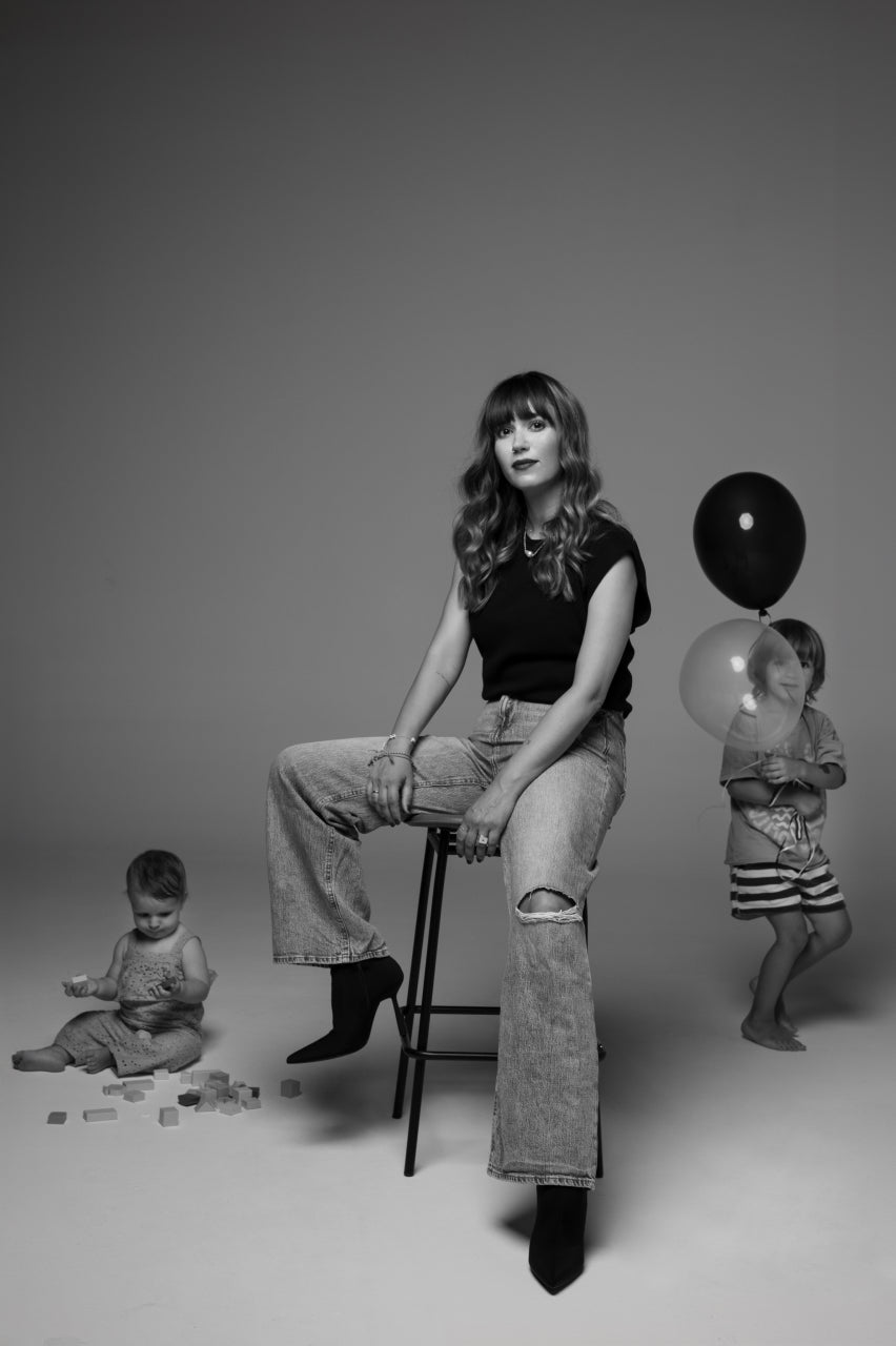 Woman sitting with kids playing